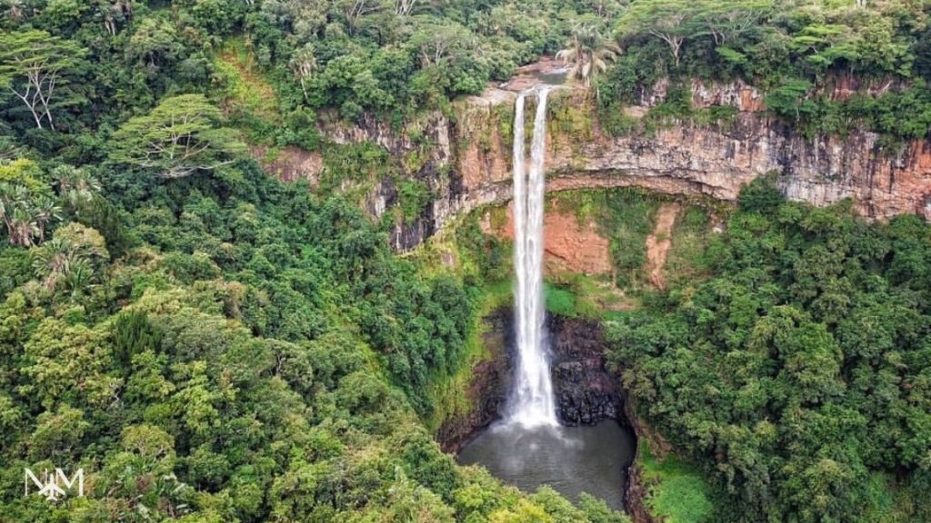 an aerial view over the Chamarel waterfall in Mauritius tropical island with a 100m drop into the base